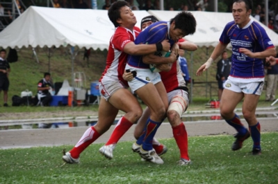 タックルされながらも必死にボールをキープする菅野朋幸選手
